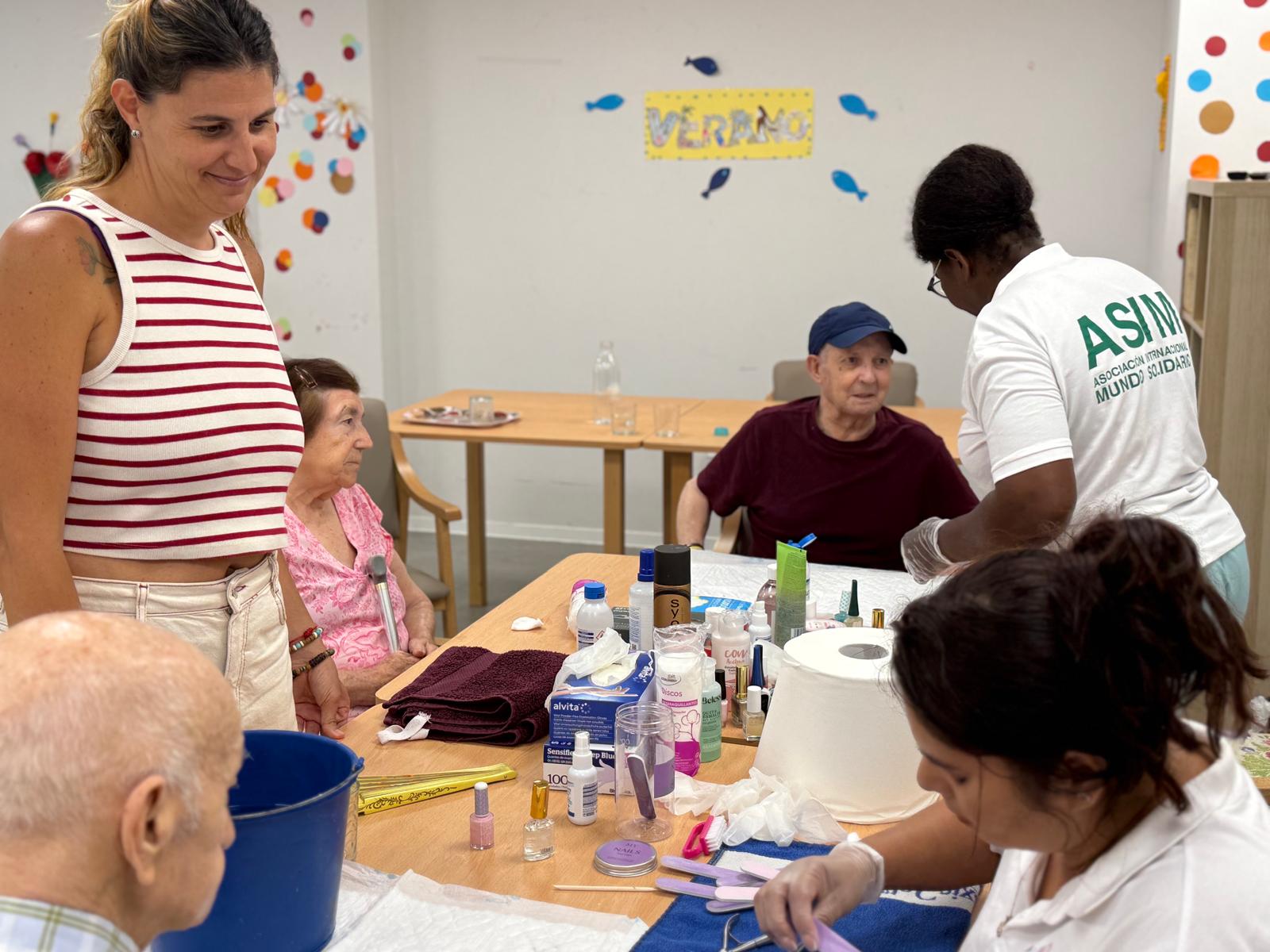 Mesa de cuidados con voluntarias de ASIM atendiendo a varias personas mayores